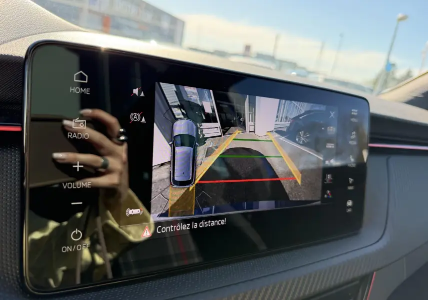 Écran tactile intérieur du Skoda Kamiq bleu 2025 montrant la caméra de recul avec guidage de trajectoire.