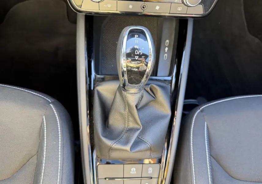 Vue rapprochée de la console centrale du Skoda Kamiq 2025 montrant le levier de vitesse automatique et les sièges noirs.