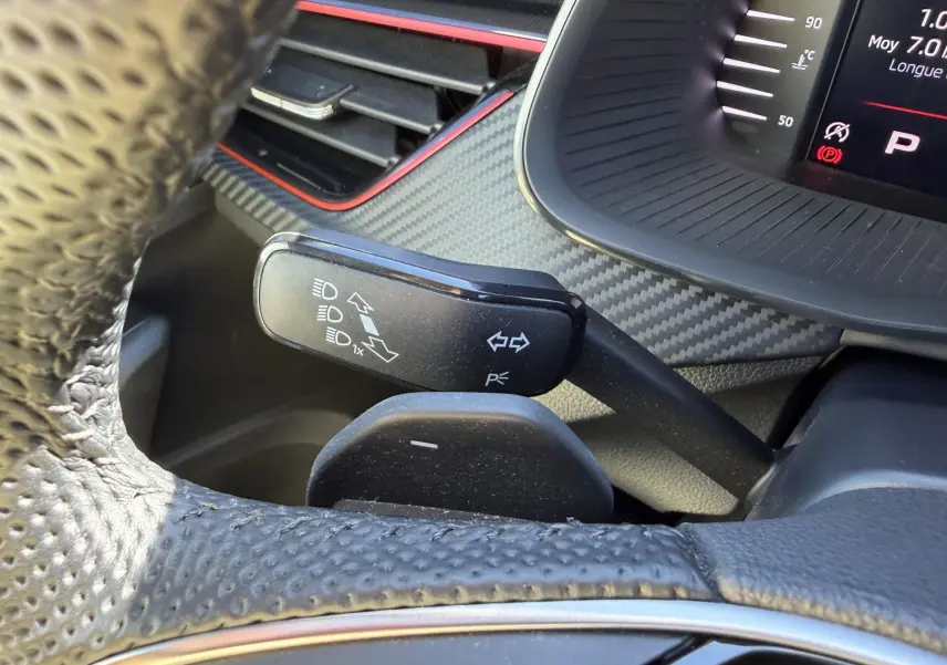 Gros plan sur la manette de clignotants noire et volant sport en cuir perforé dans l’habitacle du Skoda Kamiq 2025.