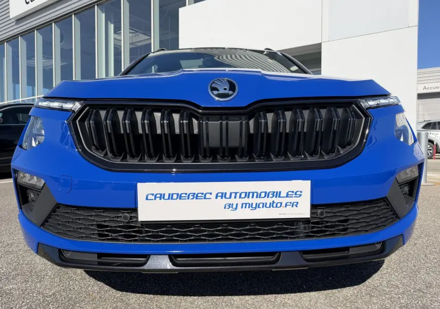 Vue frontale rapprochée du Skoda Kamiq bleu 2025 avec calandre noire et projecteurs LED haute gamme.