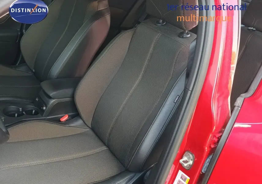 Vue intérieure côté conducteur sur les sièges en tissu et cuir noir du DS3 Crossback rouge métal avec porte ouverte.