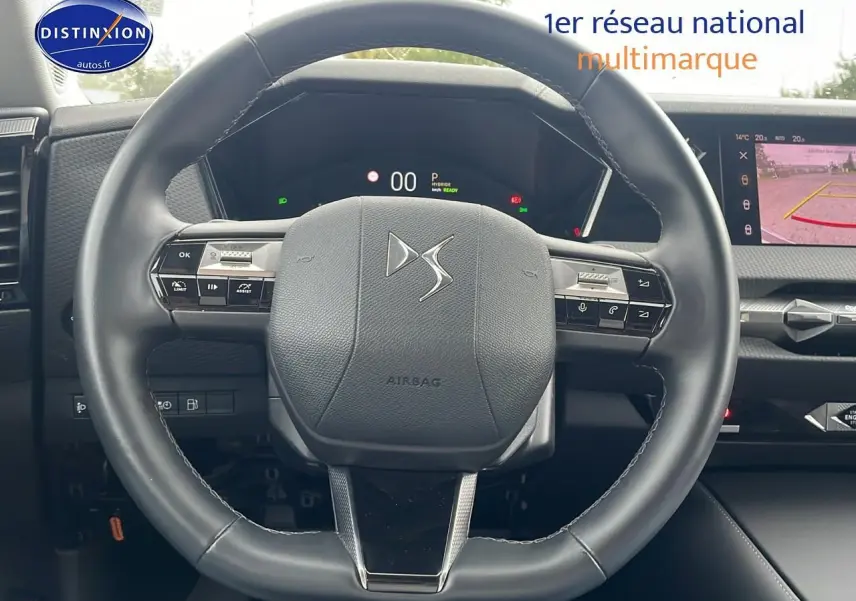 Volant cuir noir avec logo DS au centre, tableau de bord numérique et écran tactile affichant la caméra de recul.