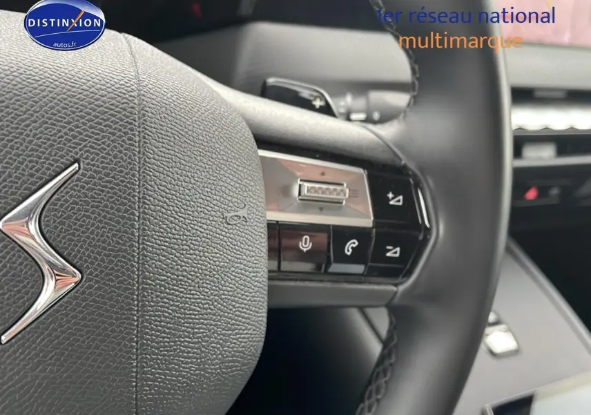 Gros plan sur le volant cuir noir du DS4 E-tense 225 avec commandes vocales et palettes au volant.