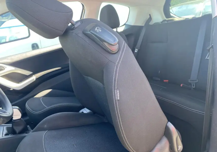 Intérieur de la Peugeot 208 gris foncé, vue côté gauche sur siège avant rabattable et banquette arrière noire.