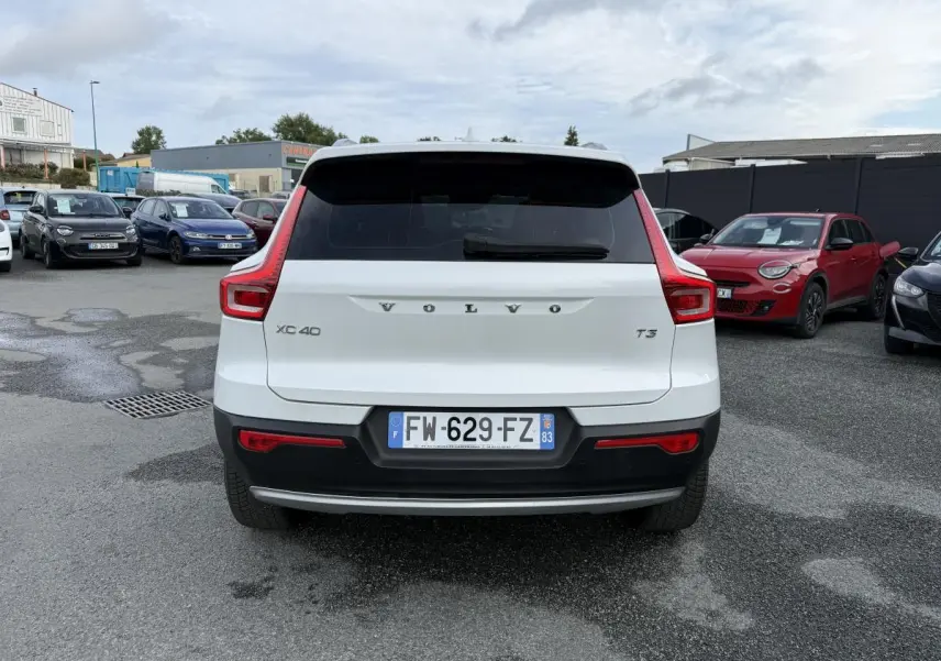 Vue arrière d'un Volvo XC40 T3 blanc avec feux arrière en forme de L et pare-chocs noir contrastant.
