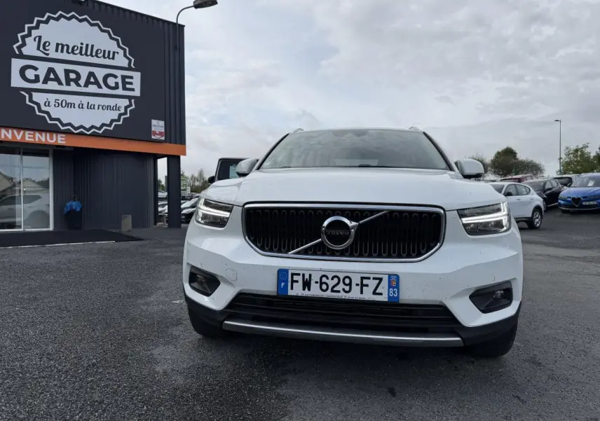 Vue de face d'un Volvo XC40 blanc avec calandre noire et feux LED en forme de marteau de Thor.