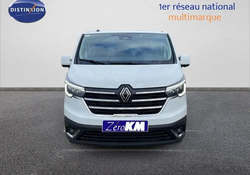 Vue frontale d'un Renault Trafic Fourgon blanc glacier avec calandre chromée et phares LED allumés.
