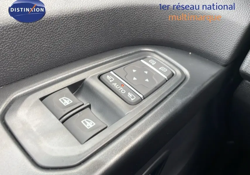 Panneau de commandes des vitres électriques côté gauche dans l'habitacle du Renault Trafic Fourgon blanc glacier.