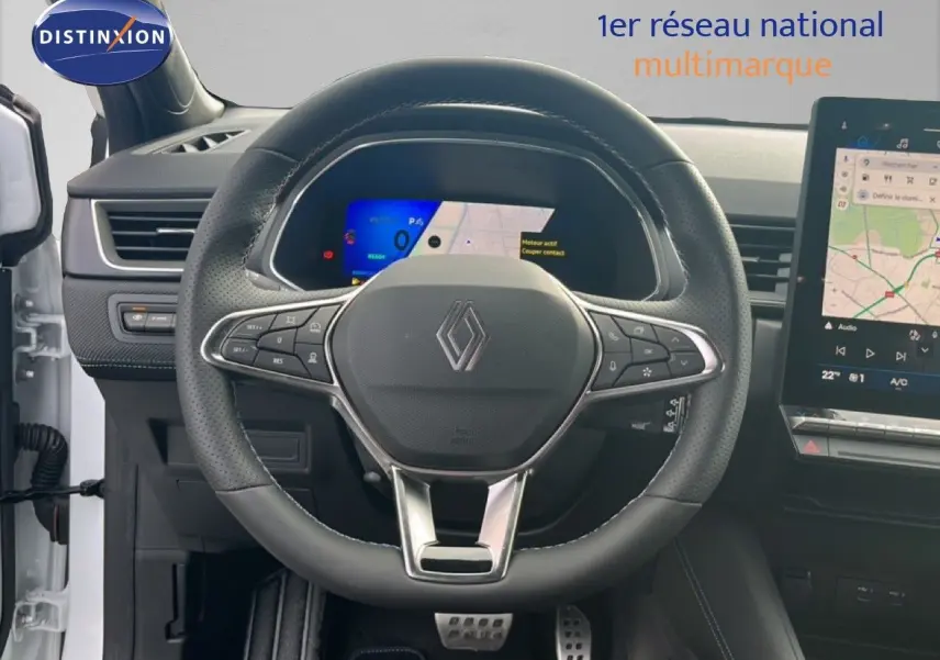 Vue intérieure centrée sur le volant noir perforé et le tableau de bord numérique d’une Renault Symbioz blanc nacré 2025.