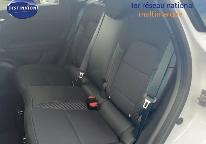 Vue intérieure côté droit montrant les sièges arrière noirs avec surpiqûres et ceinture de sécurité bleue d'une Renault Symbioz blanche nacrée.