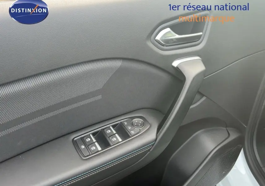 Gros plan sur la porte avant gauche de la Renault Symbioz blanche nacrée, montrant les commandes des vitres et la poignée intérieure.