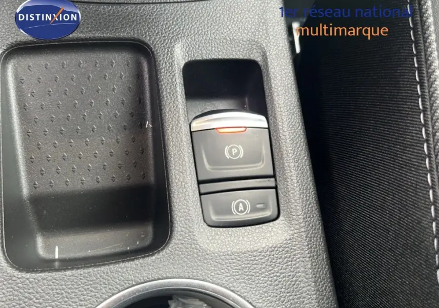 Gros plan sur la console centrale du Renault Symbioz blanc nacré, mettant en valeur les boutons de frein à main et auto start-stop.