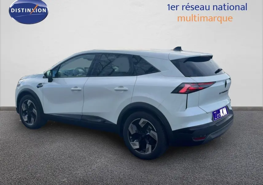 Renault Symbioz blanc nacré métal vu de 3/4 arrière droit, avec jantes noires et feux arrière LED distinctifs.