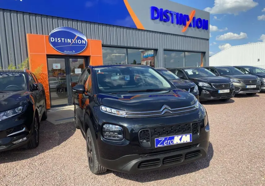 Citroën C3 Aircross noir vue 3/4 avant droit, avec calandre distinctive et plaque "Zero KM" devant un concessionnaire.