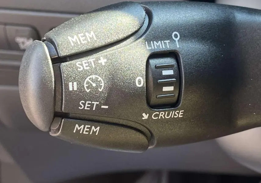 Gros plan sur la commande de régulateur de vitesse noire dans l’habitacle d’une Citroën C3 Aircross 2021 noire.