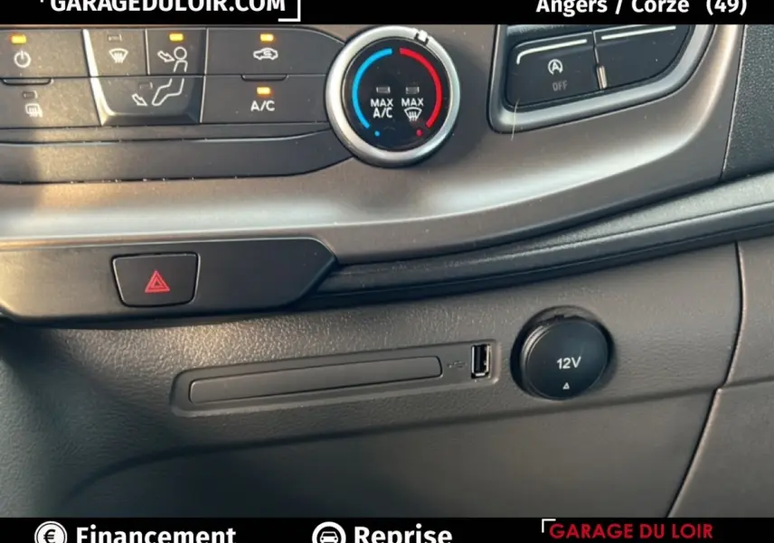 Détail de la console centrale du Ford Transit Custom blanc, montrant les commandes de climatisation et prise USB 12V.