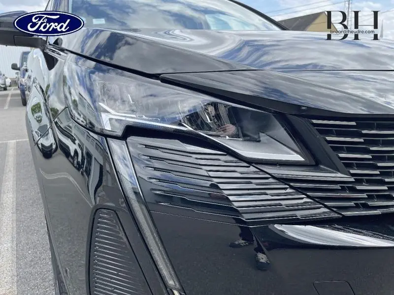 Gros plan sur l'avant droit noir Perla Nera du Peugeot 5008 2021, mettant en valeur le phare LED et la calandre chromée.