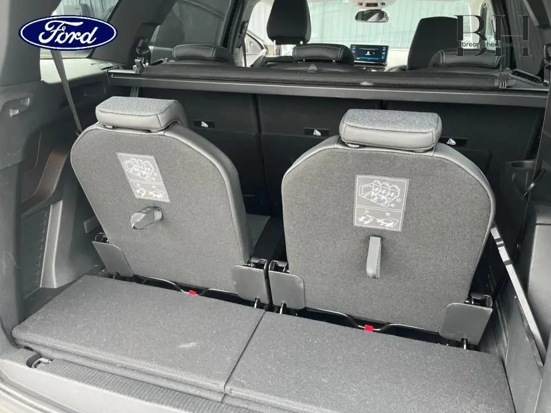 Vue arrière du coffre du Peugeot 5008 noir Perla Nera avec sièges rang 3 relevés et tablette arrière visible.