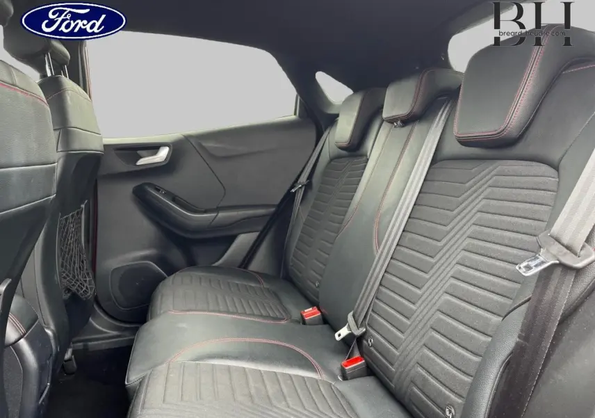 Vue intérieure montrant la banquette arrière en tissu noir avec surpiqûres rouges du Ford Puma 2020.
