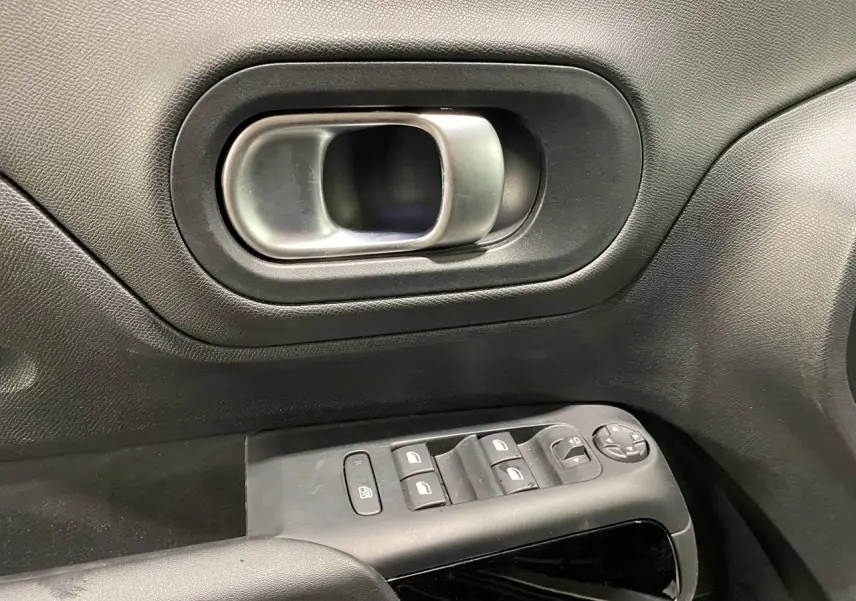 Poignée intérieure de porte côté gauche avec commandes de vitres et rétroviseurs sur Citroën C5 Aircross gris platinium 2023.