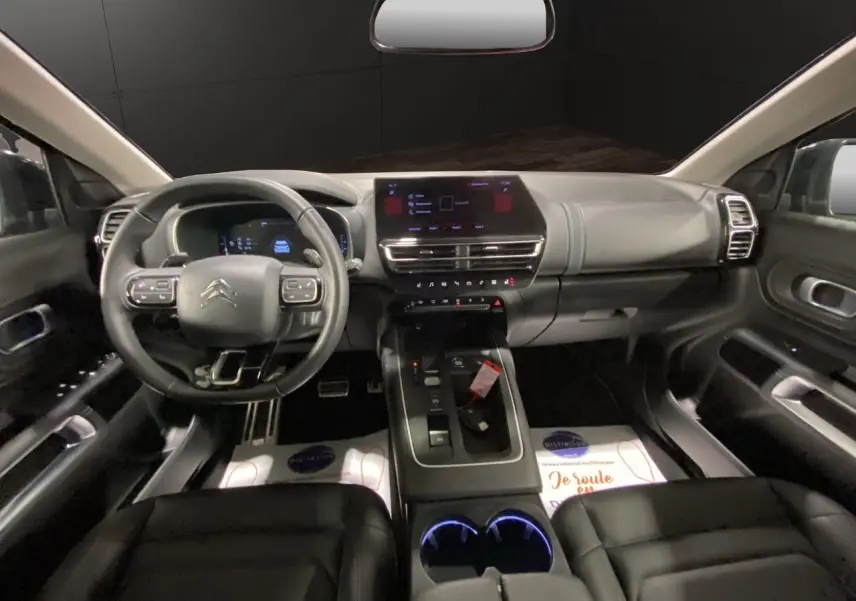 Vue intérieure avant du Citroën C5 Aircross 2023, tableau de bord moderne avec écran tactile et volant multifonction noir.