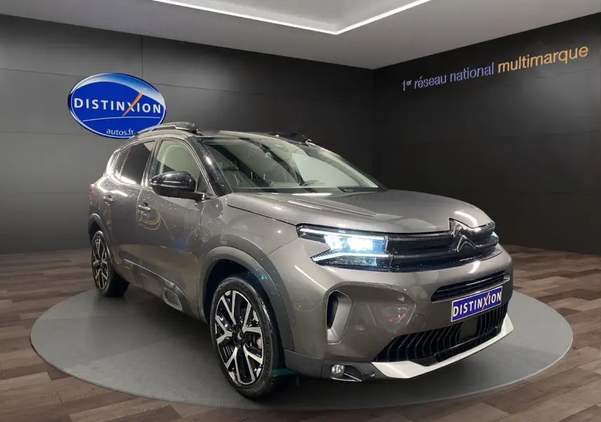 Vue 3/4 avant du Citroën C5 Aircross gris platinium avec feux LED allumés et jantes alliage noires.