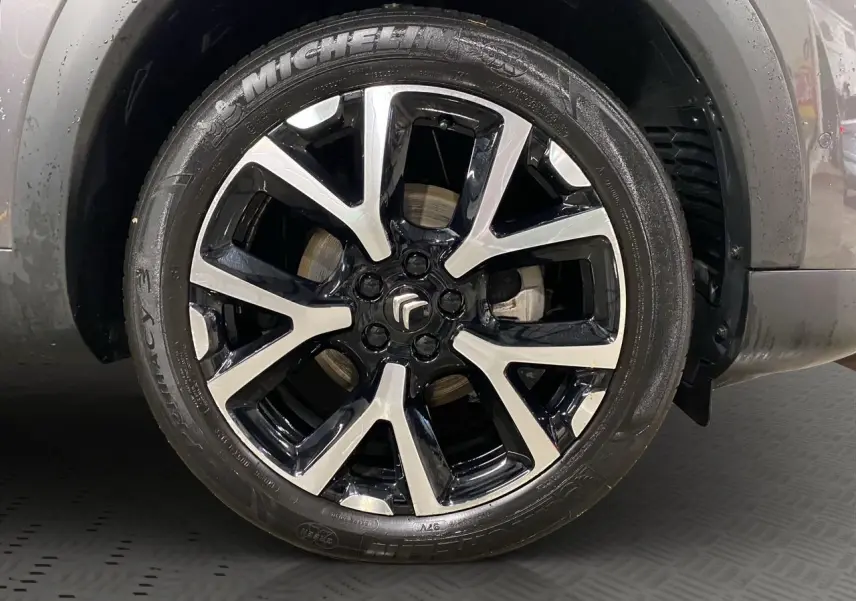 Gros plan sur la jante alliage bicolore noire et argentée d’un Citroën C5 Aircross gris platinium.