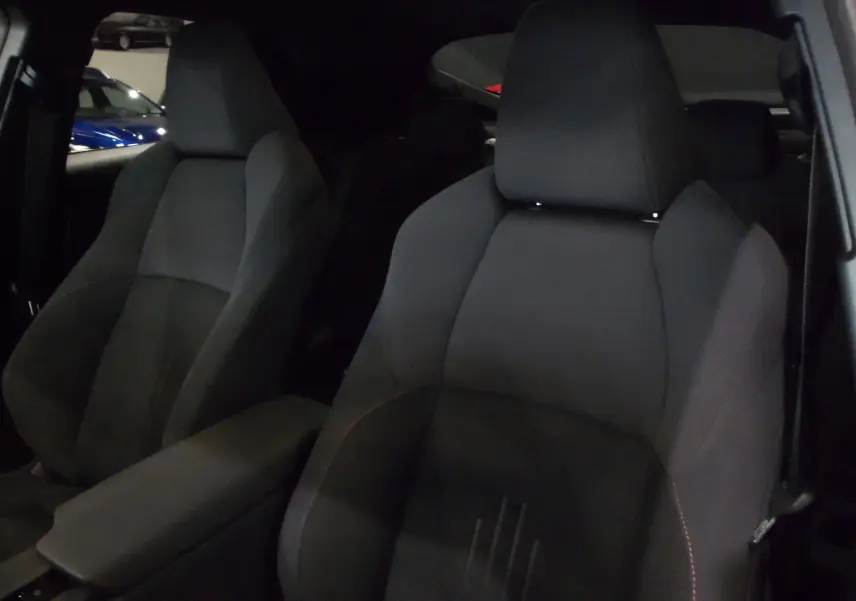 Gros plan sur les sièges avant en tissu noir du Toyota C-HR Hybride 140 CH Style 2025, intérieur sobre et moderne.