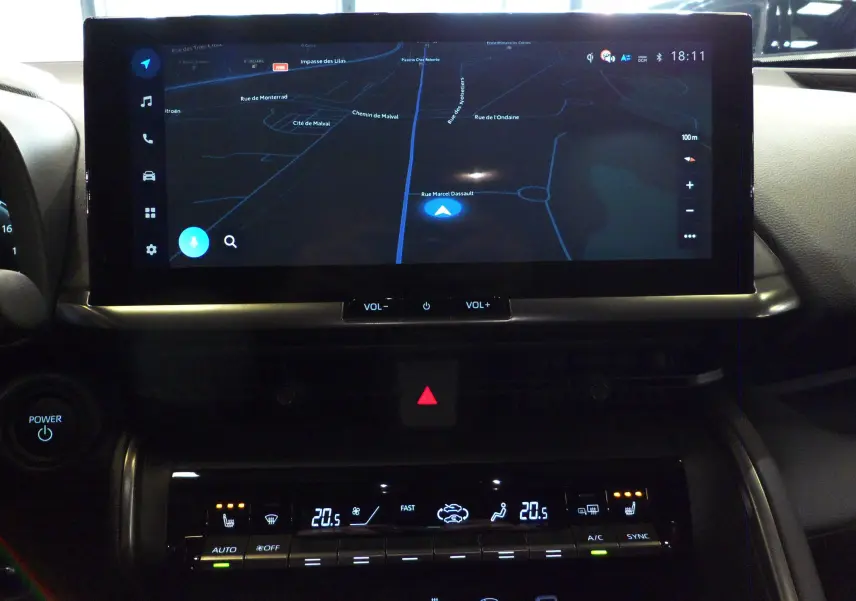 Tableau de bord du Toyota C-HR hybride 2025 avec écran tactile GPS et commandes climatisation digitales.