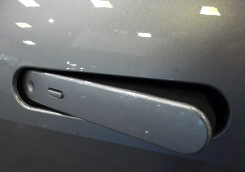 Poignée de porte gris minéral en gros plan sur Toyota C-HR Hybride 140 CH Style 2025, finition lisse et intégrée.
