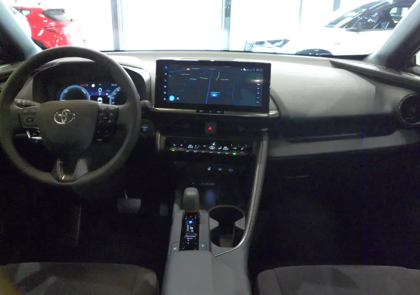 Intérieur du Toyota C-HR hybride 2025, vue frontale du tableau de bord avec écran tactile et volant multifonction.