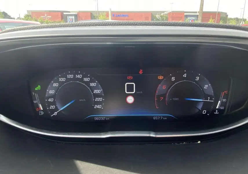 Tableau de bord numérique du Peugeot 3008 blanc 2018 affichant vitesse et compte-tours, vue frontale intérieure.