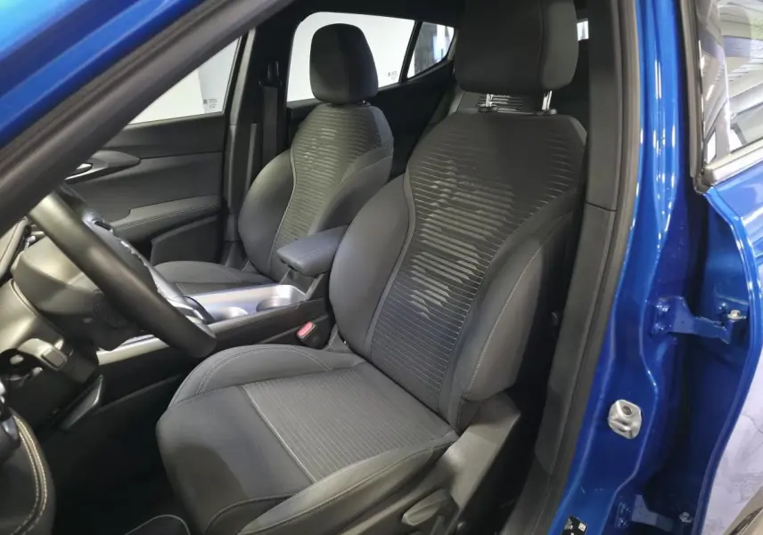 Vue intérieure côté conducteur de l'Alfa Romeo Tonale 2025 bleu, sièges tissu noir avec surpiqûres beige et volant cuir.