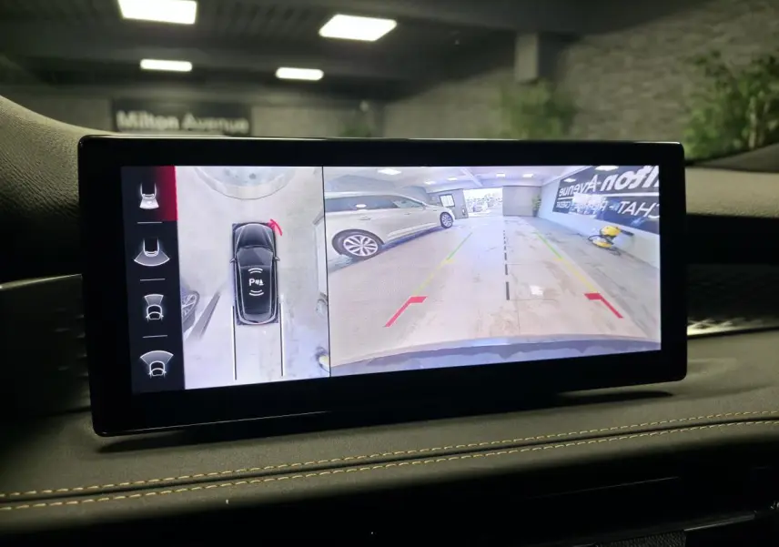 Écran intérieur affichant la caméra 360° et l'aide au stationnement du tableau de bord de l'Alfa Romeo Tonale bleu.