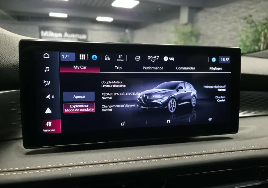 Écran tactile intérieur affichant une Alfa Romeo Tonale bleu en vue 3/4 avant avec détails des modes de conduite.