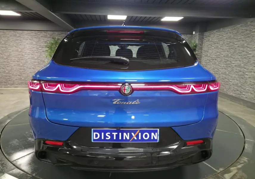 Vue arrière d'une Alfa Romeo Tonale bleue 2025 avec feux LED distinctifs et logo central sur hayon noir brillant.