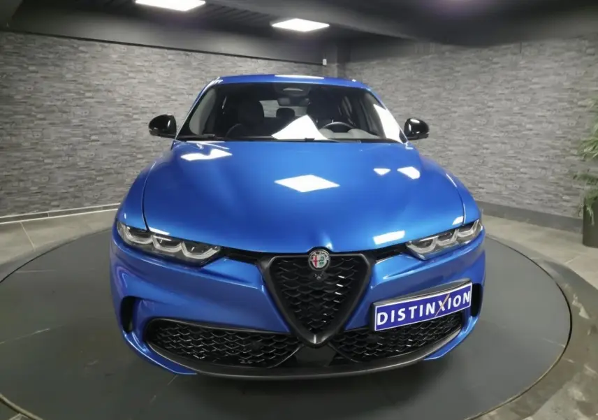 Vue frontale d'une Alfa Romeo Tonale Sprint 2025 bleu métallisé avec calandre noire et phares LED distinctifs.
