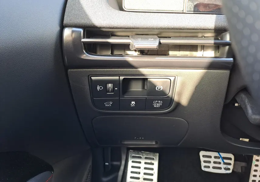 Vue intérieure du tableau de bord côté conducteur du Hyundai Tucson 2025, avec commandes de réglage des phares et frein de stationnement.