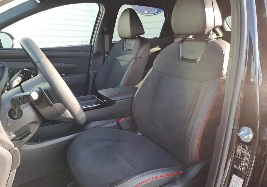 Vue intérieure côté conducteur du Hyundai Tucson 2025 Abyss Black, sièges en cuir Alcantara noir avec surpiqûres rouges et logo N.