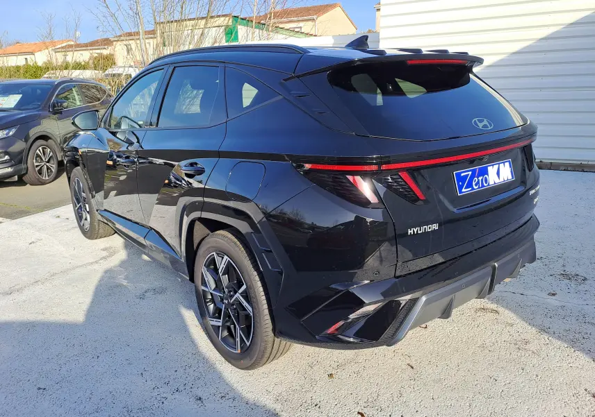 Vue 3/4 arrière droite du Hyundai Tucson 2025 en noir abyss, avec feux arrière LED et jantes alliage distinctives.