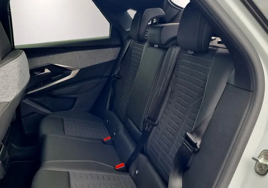 Vue latérale droite de l’arrière d’un Peugeot 3008 blanc avec sièges arrière noirs et tissu texturé.