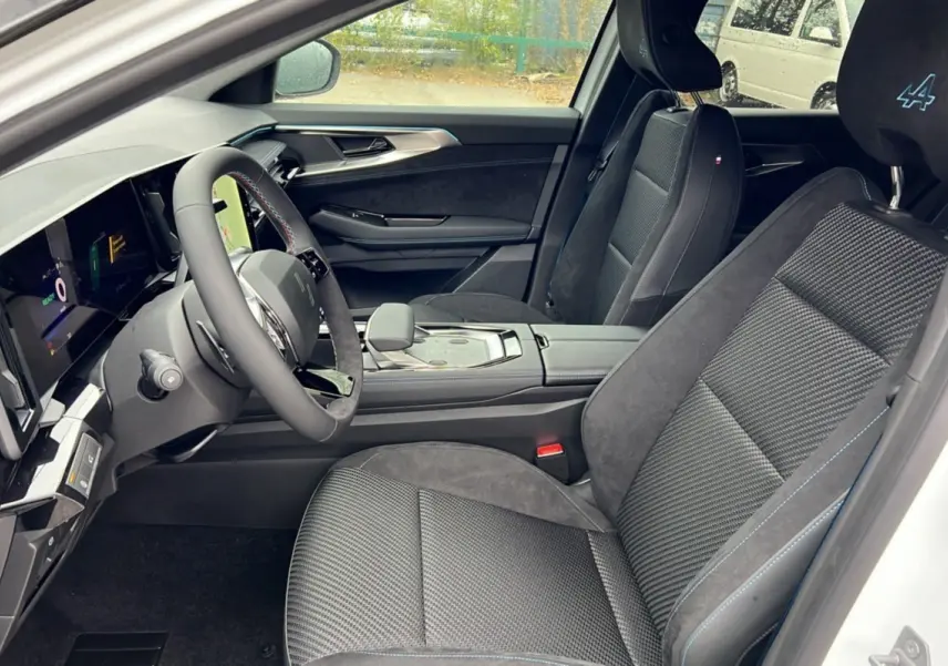 Vue intérieure côté conducteur du Renault Austral ETECH 200 Esprit Alpine Plus 2025 avec sièges noirs et surpiqûres bleues.