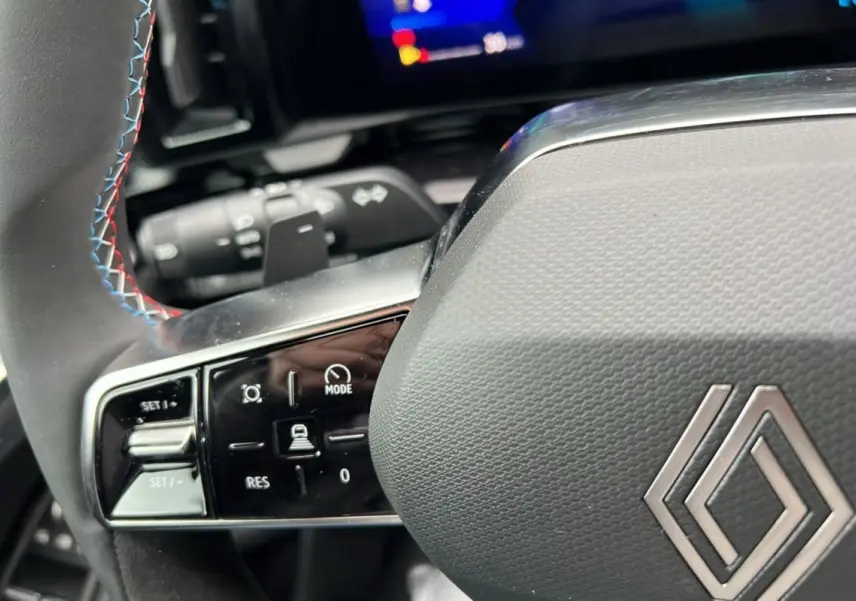 Gros plan sur le volant du Renault Austral E-Tech 200 Esprit Alpine Plus 2025, cuir noir avec surpiqûres tricolores.