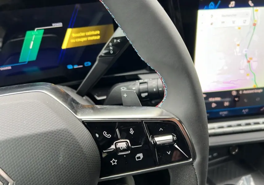 Détail du volant avec commandes intégrées et écran tactile affichant la navigation dans le Renault Austral E-Tech 2025.