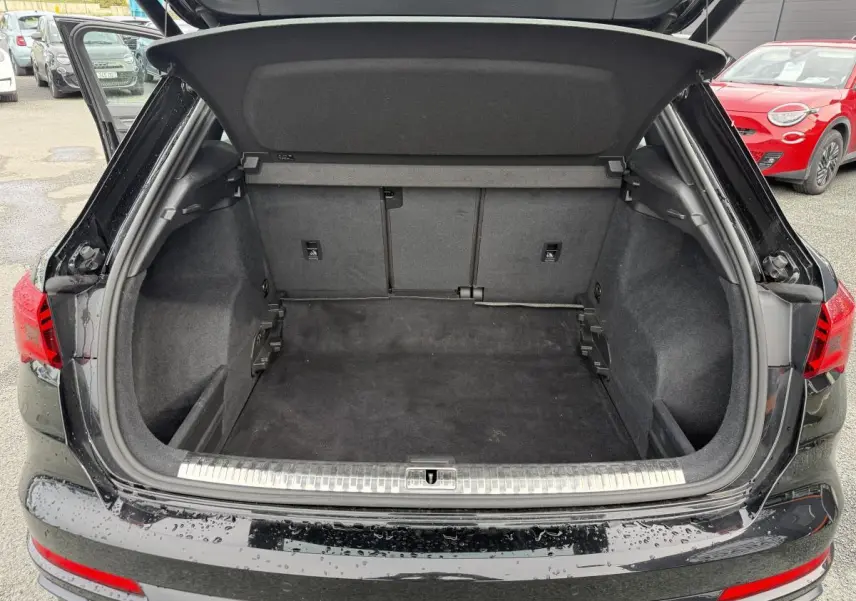 Coffre ouvert vu de l'arrière d'un Audi Q3 noir 2019 avec seuil de chargement en acier inoxydable.