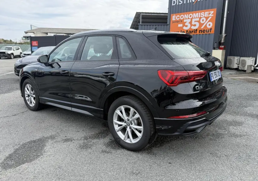 Audi Q3 Quattro 2.0 35 TDI S Line noir métallisé vue 3/4 arrière droit sur parking humide