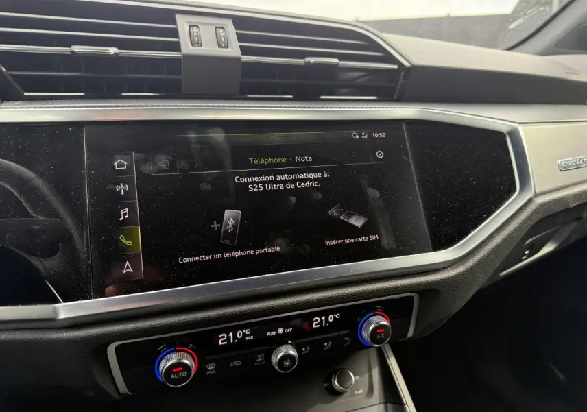 Vue rapprochée de la console centrale et écran tactile du tableau de bord de l'Audi Q3 noir 2019 Quattro S Line.