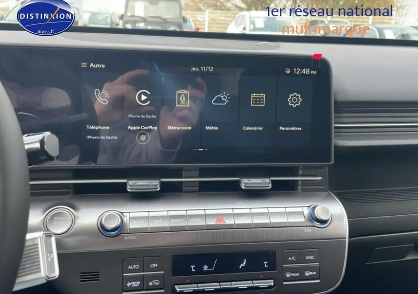 Vue intérieure du tableau de bord du Hyundai Kona 2025, écran tactile large avec Apple CarPlay affiché.
