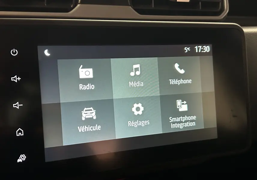 Écran tactile central du tableau de bord du Dacia Duster 2023, affichant les menus radio, média, téléphone et réglages.