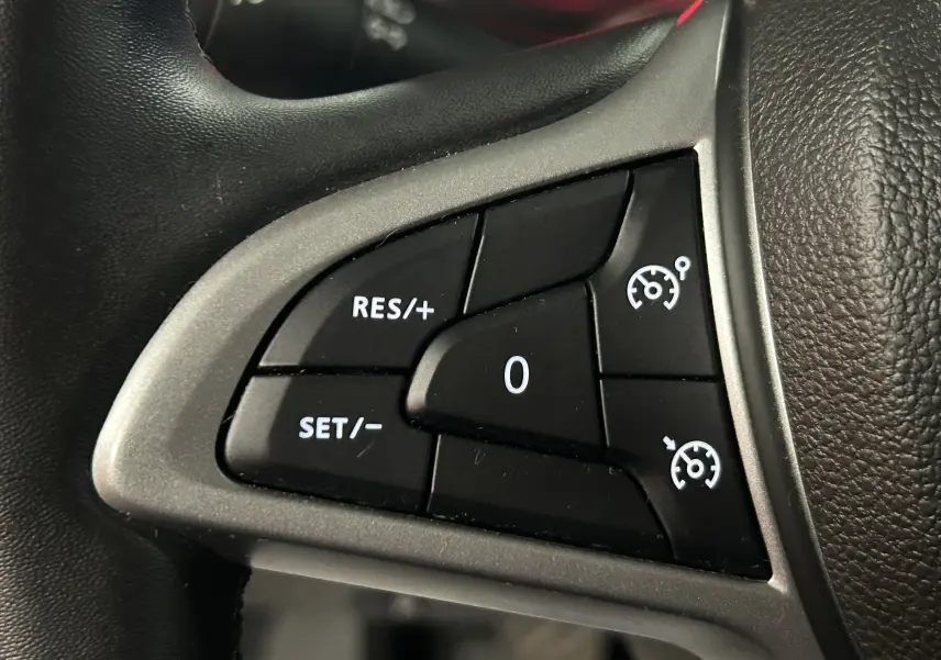 Gros plan sur les commandes de régulateur de vitesse au volant d’un Dacia Duster 2023, finition Expression.